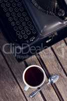 Vintage typewriter and cup of black coffee