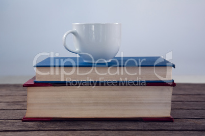 Books with cup of coffee on wooden table