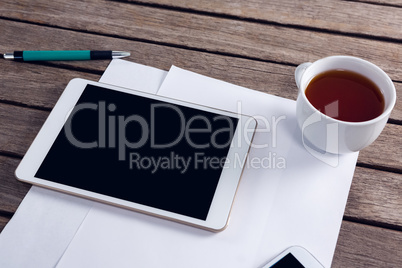 Digital tablet, black coffee and blank paper on wooden table Digital tablet, black coffee and blank paper on wooden table