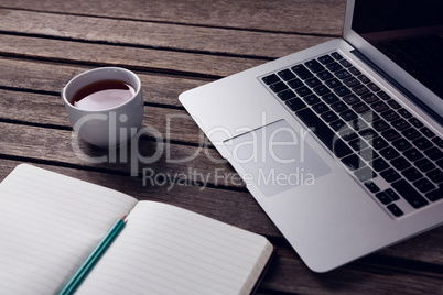 Laptop, black coffee and diary on wooden table Laptop, black coffee and diary on wooden table