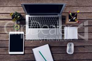 Electronic gadgets and office supplies on wooden table