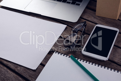 Electronic gadgets and office supplies on wooden table