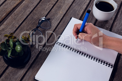 Executive writing in organizer at office