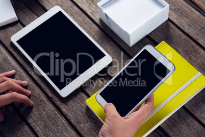 Executive holding mobile phone at desk