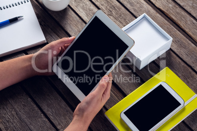 Executive holding digital tablet at desk