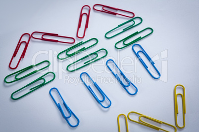 Colorful paper clips arranged on white background