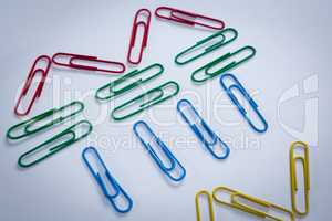 Colorful paper clips arranged on white background
