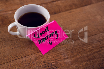 Black coffee with message on wooden plank