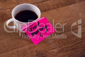 Black coffee with message on wooden plank