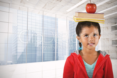 Composite image of girl balancing books and apple on head