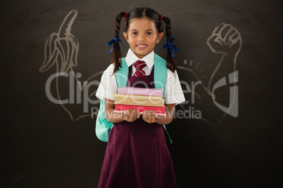 Composite image of smiling schoolgirl carrying books