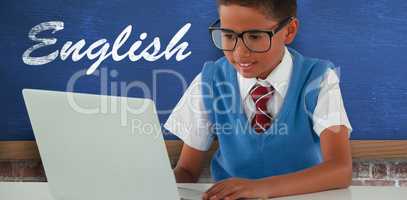Composite image of schoolboy using laptop at table