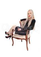 Beautiful woman in a black dress in armchair