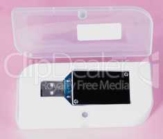 electronic device in plastic case on pink background at day