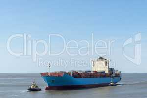 Containerschiff und Schlepper
