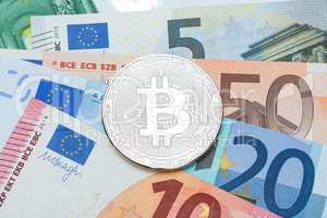 Silver Bitcoin close-up. Background euro currency. Conceptual ph