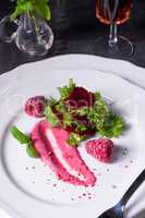 Carpaccio of baked red pray with green salad and raspberry