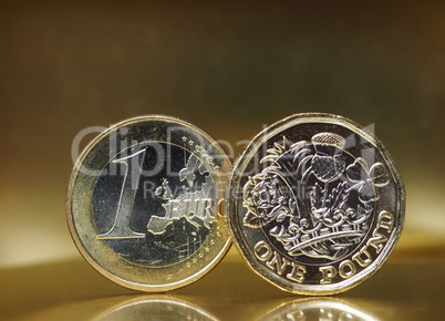 1 pound and 1 euro coin over metal background