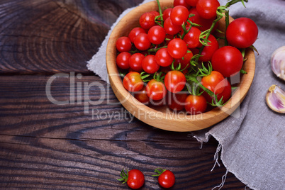 Fresh red cherry tomatoes in a wooden plate