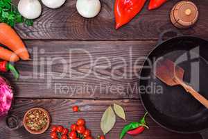 Black frying pan and fresh vegetables