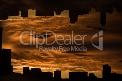 Silhouette city against cloudy sky during sunset