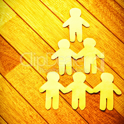 Paper cut out figures forming human pyramid