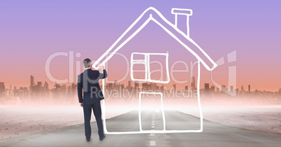 Business man drawing a house on the road