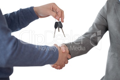 Business man giving keys and shaking hands