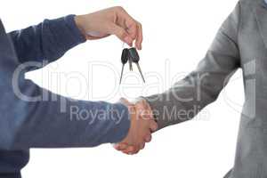 Business man giving keys and shaking hands