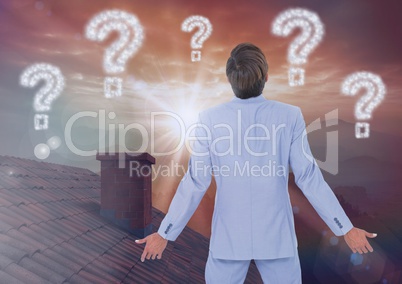Question marks and Businessman standing on Roof with chimney and epic twilight sunset