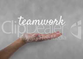 Hand interacting with teamwork business text against grey background