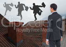 Businessman standing on Roofs with chimney and fog looking at businessman silhouettes running with b