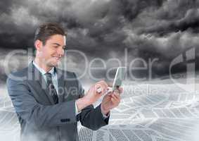 Businessman on phone in sea of documents under dark sky clouds