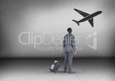 Businessman with travel bag looking up with plane icon