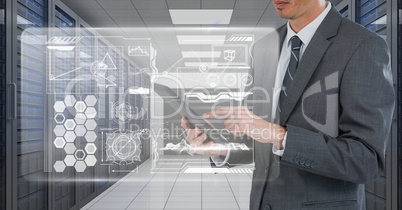 Business man holding a tablet and graphics in server room