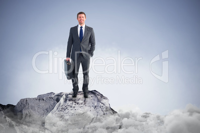 Composite image of businessman standing with his briefcase