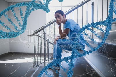 Worried doctor woman sitting with 3D DNA strands