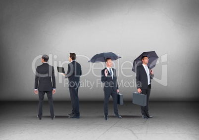 Group of Businessmen with umbrellas looking in opposite directions