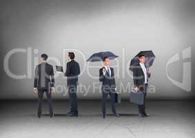 Group of Businessmen with umbrellas looking in opposite directions