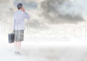Businesswoman under sky clouds with briefcase