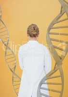 Doctor woman standing with 3D DNA strands against yellow background