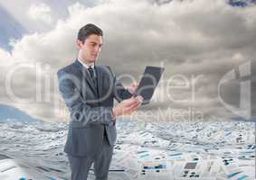 Businessman on tablet in sea of documents under sky clouds