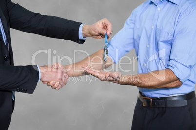 Business man giving keys and shaking hands