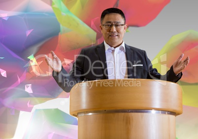 Businessman on podium speaking at conference with colorful background