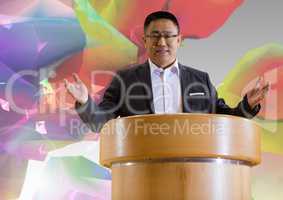Businessman on podium speaking at conference with colorful background