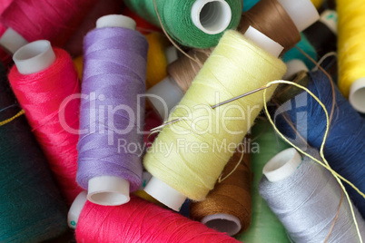 Pile of coloured bobbins of thread