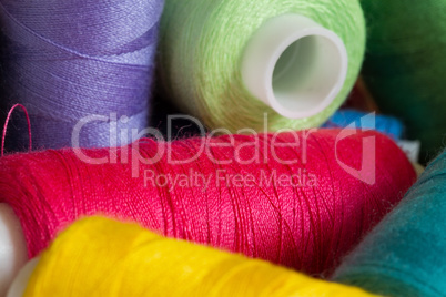 Pile of coloured bobbins of thread