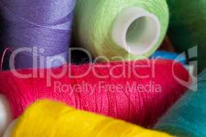 Pile of coloured bobbins of thread