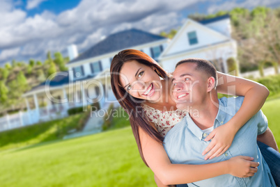 Playful Young Military Couple Outside A Beautiful New Home.