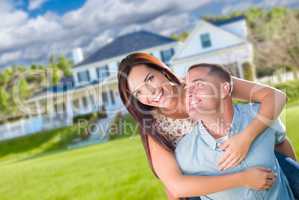 Playful Young Military Couple Outside A Beautiful New Home.